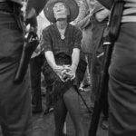 Dorothy Day on UFW picket line faces sheriff. When arthritis made standing difficult, Day confronted sheriffs from her portable three-legged golf stool. Lamont, California, August 1973.