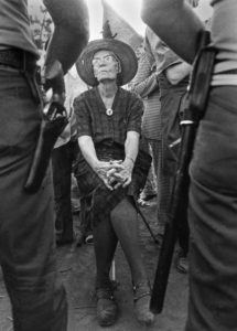 Dorothy Day on UFW picket line faces sheriff. When arthritis made standing difficult, Day confronted sheriffs from her portable three-legged golf stool. Lamont, California, August 1973.